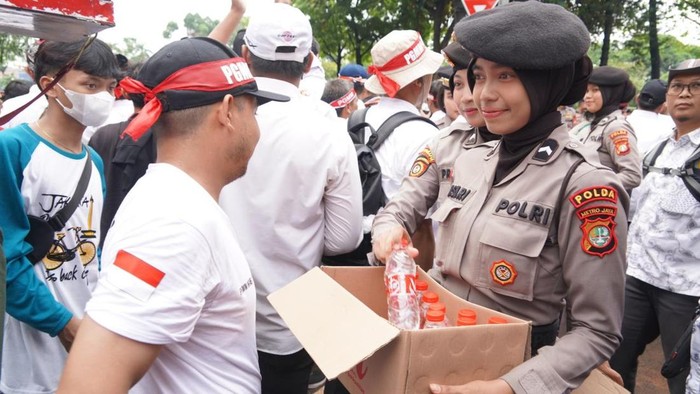 Aksi humanis polwan membagikan air mineral dan roti kepada guru honorer peserta aksi di DPR, Rabu (20/5/2026) siang.