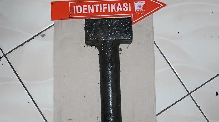 Barang bukti palu yang ditemukan di selokan dekat TKP.
