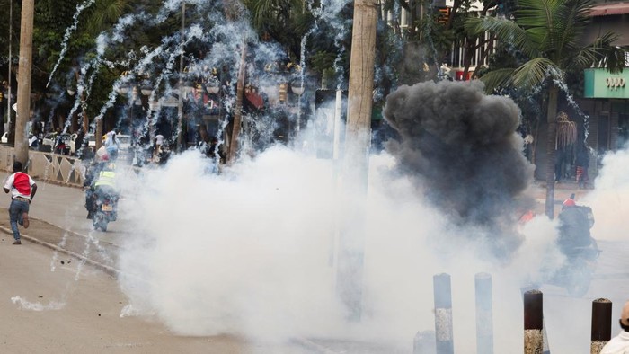 People run as police officers use teargas to disperse protesters during a strike by public transport operators driven by rising fuel costs linked to global supply pressures due to the war in Iran, in downtown Nairobi, Kenya, May 18, 2026. REUTERS/Monicah Mwangi