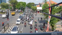 Massa Ojol terlihat memadati Jalan Urip Sumoharjo. Mereka sambil membawa atribut, spanduk, dan bendera komunitas saat konvoi menuju titik aksi.