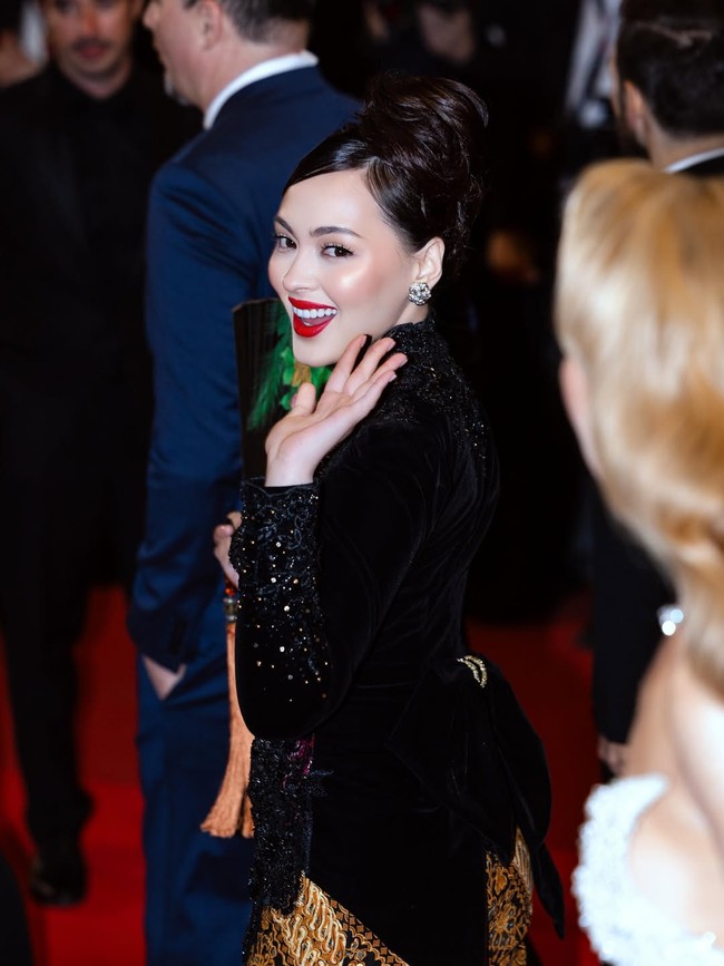 Jolene bukan yang pertama memakai kebaya di karpet merah Cannes, tapi gayanya berbeda karena pendekatan yang sangat klasik. Kebaya full brokat hitam itu dilengkapi stagen jumputan berwarna merah dan bawahan batik bernuansa sogan. (Foto: Instagram/@joleneemarie)