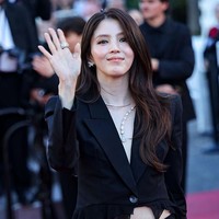 Sang aktris menampilkan gaya bold dan edgy dalam balutan busana serba hitam. Ia mengenakan blazer satin berkerah rendah dengan aksen ruffle dari koleksi rumah mode Italia, Blumarine tanpa dalaman yang mengekspos perhiasannya. Foto: Getty Images