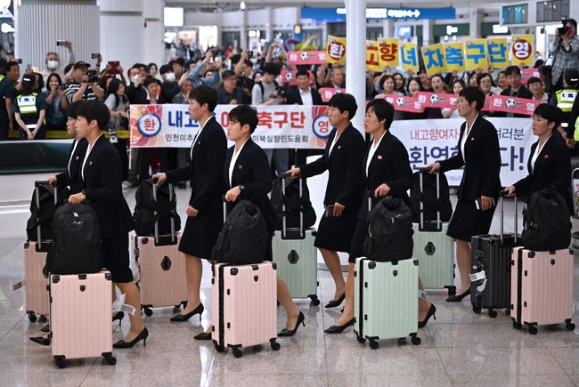 Puluhan warga dan kelompok sipil Korea Selatan turut menyambut kedatangan tim tersebut dengan membawa papan ucapan selamat datang. Pengamanan di area bandara juga terlihat cukup ketat selama rombongan berjalan menuju bus. “Kami menyambut kalian!” seru para pendukung saat para pemain melintas menuju kendaraan mereka. Foto: AFP/JUNG YEON-JE