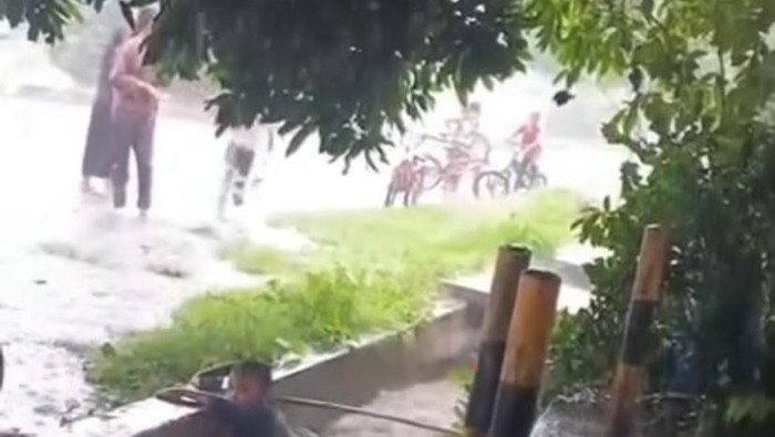 Seorang bocah saat terbawa arus banjir dalam drainase.