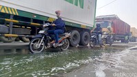 Genangan sisa banjir rob masih terlihat di beberapa titik jalan. Sementara kendaraan melintas perlahan agar tidak terjermbab lubang jalan.