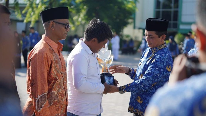 Wakil Wali Kota Pontianak Bahasan menyerahkan Penghargaan Proklim Utama Trophy kepada perwakilan Kampung Gambut.