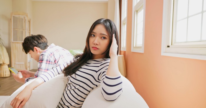 technology and relationship problem concept - Asian man addicts social network media or video games and ignore couple relationship at home while woman is annoyed about their communication problems