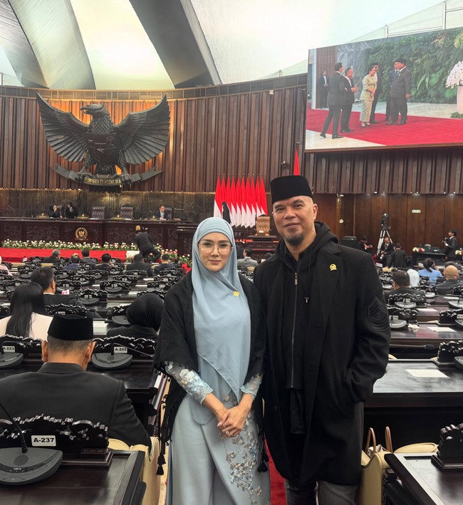 Keduanya memilih tampil simpel. Mulan memilih busana panjang berwarna abu-abu. Busana tersebut dipadukan dengan hijab polos senada dan outer hitam yang senada dengan busana Ahmad Dhani. Foto: Instagram/@mulanjameela1