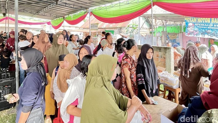 Warga mengantre untuk membeli bahan pokok di pasar murah.