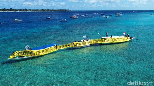Warga Dusun Gili Meno, Desa Gili Indah, Lombok Utara, NTB, membentangkan spanduk protes di tengah laut terkait kondisi krisis air bersih, Kamis (21/5/2026). (Foto: Sanusi Ardi W/detikBali)
