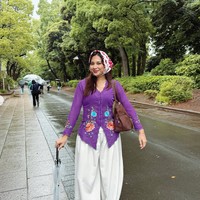 Indah tampil memukau dengan kebaya modern warna ungu. Kebaya tersebut memiliki model fitted di bagian tubuh sehingga memberi siluet ramping. Ia memadukan kebaya tersebut dengan celana kulot longgar warna putih gading. Foto: Instagram/@arie_kriting