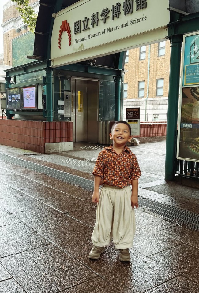 Kompak dengan sang mama, Naka juga  mengenakan celana kulot panjang dengan model mirip, namun berwarna krem. Untuk atasannya, Naka mengenakan kemeja batik coklat lengan pendek. Foto: Instagram/@arie_kriting