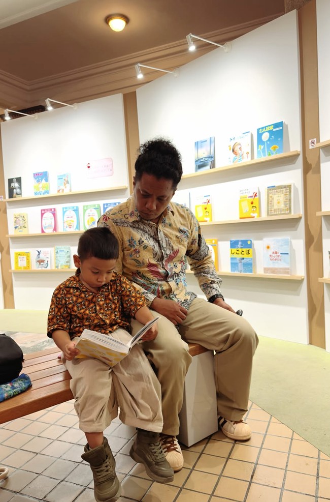 Naka tampak asik membaca buku ditemani ayahnya saat berada di museum tersebut. Foto: Instagram/@arie_kriting