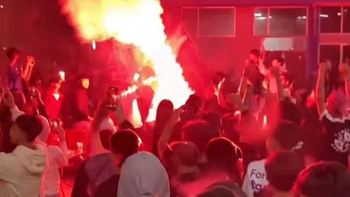 Bobotoh menyalakan flare atau suar dalam perayaan juara di kafe Jalan Pahlawan, Indramayu, Sabtu (23/5/2026) sore.