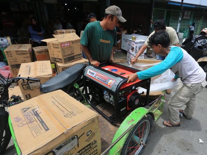 Pedagang mengangkat mesin pembangkit jaringan listrik generator set (genset) seusai dibeli di salah satu tempat penjualan genset Meulaboh, Aceh Barat, Aceh, Sabtu (23/5/2026). Para pedagang mengaku penjualan pembangkit listrik generator set (genset) dengan daya 1.000 hingga 7.000 ribu watt mengalami peningkatan dari biasanya dua genset menjadi 45 genset per hari akibat dampak pemadaman listrik yang dipicu gangguan pada sistem transmisi interkoneksi Saluran Udara Tegangan Tinggi (SUTET) 275 kV lintas Sumatera. ANTARA FOTO/Syifa Yulinnas/foc.