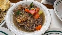 Kalau mau yang berkuah gurih segar, bisa pesan Sop Buntut Klasik (Rp 57.273). Daging yang empuk disajikan bersama irisan tomat, wortel, serta kentang. Disiram kuah kaldu yang warnanya agak cokelat pekat.Foto: Detikcom / Atiqa Rana