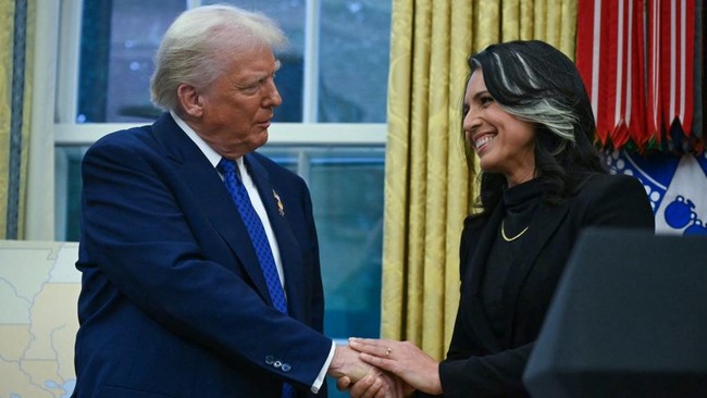 (FILES) US President Donald Trump shakes hands with Tulsi Gabbard after she was sworn in as Director of National Intelligence (DNI) in the Oval Office of the White House in Washington, DC, on February 12, 2025. US President Donald Trump hailed intell