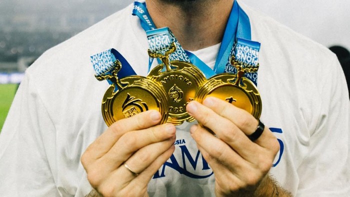 Marc Klok pamer piala dan medali.