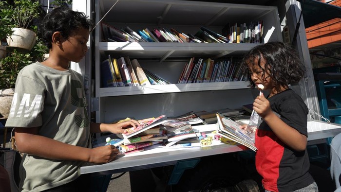 Sejumlah anak dan orang dewasa membaca buku di perpustakaan keliling di Kediri, Jawa Timur, Minggu (24/5/2026). Dinas Pemberdayaan Perempuan dan Perlindungan Anak Kota Kediri bersama Forum Anak Kota Kediri menyelenggarakan layanan perpustakaan keliling pada minggu keempat setiap bulan untuk meningkatkan minat baca, menyosialisasikan hak-hak anak, membangun kesadaran bahaya pernikahan dini, putus sekolah, dan perundungan, serta mendukung implementasi PP Tunas sebagai perlindungan anak di ruang digital. ANTARA FOTO/Prasetia Fauzani