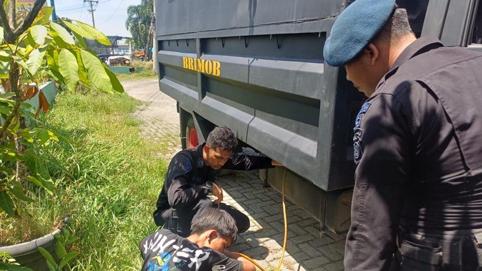Personel Brimob Polda Sumut membantu menyalurkan BBM untuk diberikan ke truk yang mogok (Foto: dok. Brimob Polda Sumut)