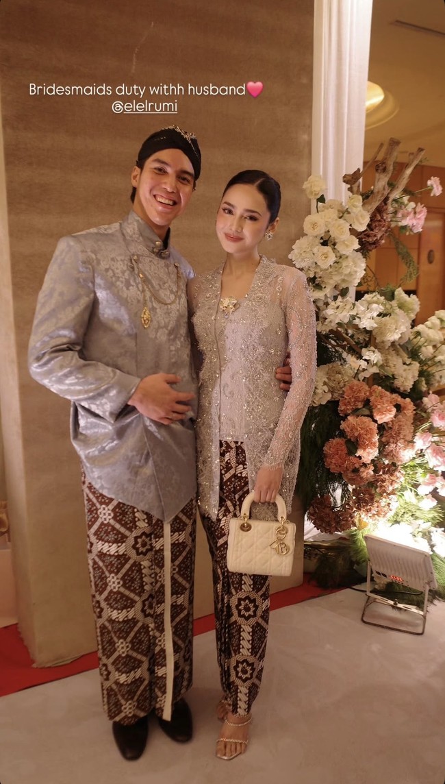 Syifa tampil anggun memakai kebaya bridesmaid warna abu-abu silver dengan sentuhan payet dan bordir. Sementara El tampil dengan beskap warna senada lengkap dengan blangkon di kepalanya. Foto: Instagram/@syifahadju