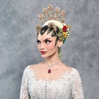Sementara untuk riasan wajah, Tengku Nadira mempercayakan pada MUA Rhay David. Makeup dibuat flawless dengan complexion matte yang halus dan memberikan efek kulit tampak sempurna. Area mata dibuat tegas dengan eyeliner tajam, bulu mata lentik, serta smokey eyes bernuansa cokelat yang memperkuat karakter paes Yogyakarta. Blush on peach lembut membuat wajahnya terlihat segar, sementara pulasan lipstik merah nude memberikan kesan elegan. Foto: Instagram/@rhay_david