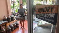 Pekerja membawa pakaian kotor di dekat galon produksi ekoenzim di tempat jasa cuci pakaian Binatu Koe, Pondok Aren, Tangerang Selatan, Banten, Senin (25/5/2026). ANTARA FOTO/Sulthony Hasanuddin