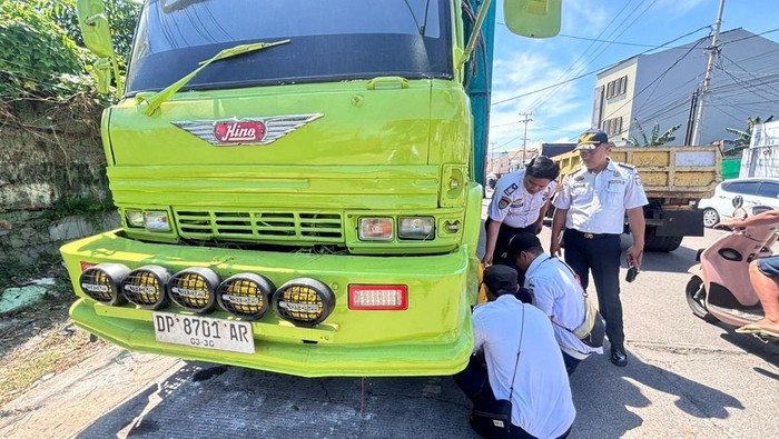 Petugas Dishub Makassar menggembok truk ekspedisi parkir badan jalan.