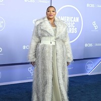 Sebagai host AMA 2026, Queen Latifah tampil powerful mengenakan coat penuh aksen bulu dengan siluet waist-cinching yang memberi aksentuasi pada pinggang. Tampilan tersebut memberi sentuhan theatrical sekaligus luxury, apalagi dengan perhiasan Marco Bicego yang dipakainya. Foto: Denise Truscello/WireImage