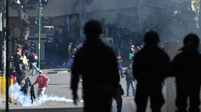 A police officer runs in front of demonstrators during a march calling for the resignation of Bolivian President Rodrigo Paz, as the country’s economic and fuel crisis worsens due to a shortage of U.S. dollars and declining domestic energy production, in La Paz, Bolivia, May 25, 2026. REUTERS/Claudia Morales     TPX IMAGES OF THE DAY