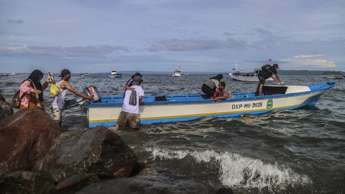 Warga mengangkut barang dagangan ke dalam perahu motor yang bersandar di tepi bebatuan Pantai Labuha, Pulau Bacan, Kabupaten Halmahera Selatan, Maluku Utara, Selasa (26/5/2026). Terbatasnya infrastruktur dermaga penyeberangan di wilayah itu membuat aktivitas bongkar muat barang menjadi terhambat dan berisiko tinggi terhadap keselamatan penumpang. ANTARA FOTO/Andri Saputra