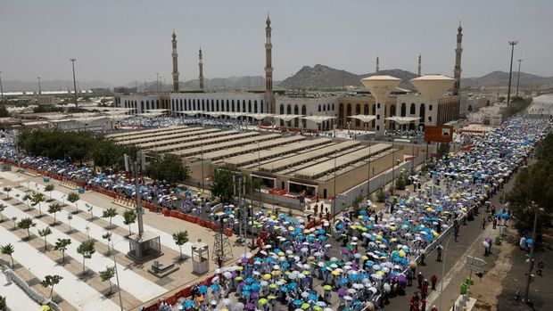 Para peziarah Muslim menggunakan payung untuk melindungi diri dari terik matahari setelah salat Zuhur di luar Masjid Nimrah di Dataran Arafat selama ibadah haji tahunan, di luar kota suci Mekah, Arab Saudi, 26 Mei 2026. (REUTERS/Ibraheem Abu Mustafa)
