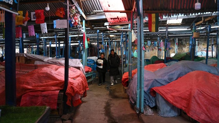 A couple walks among closed stalls in a market, as protests have caused supply chain issues in the cities of La Paz and El Alto, leading to severe shortages of food, fuel and medicine, in La Paz, Bolivia, May 25, 2026. REUTERS/Claudia Morales