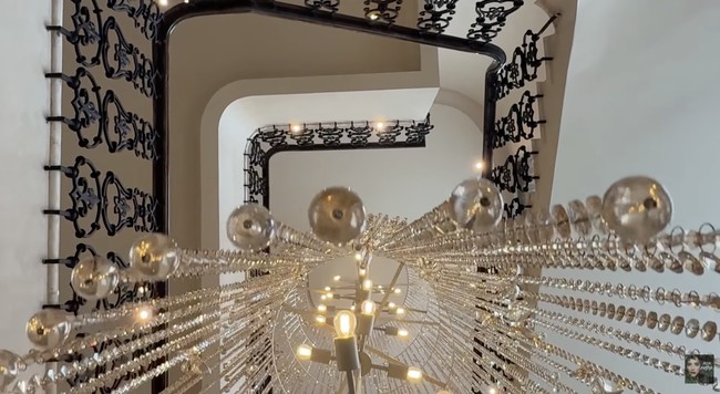 Salah satu highlight utama adalah chandelier custom yang dirancang khusus untuk rumah ini. Lampu gantung tersebut menjadi statement piece yang memperkuat kesan mewah sekaligus personal. (Foto: YouTube/tasya farasya)