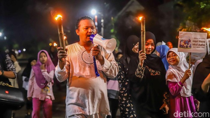 Cahaya obor menerangi jalanan Perumahan Vinewood Babelan, Kabupaten Bekasi, Jawa Barat, Selasa (26/5/2026) malam. Sejumlah warga dari berbagai usia mengikuti pawai obor keliling lingkungan untuk menyambut Hari Raya Idul Adha 1447 Hijriah yang jatuh pada Rabu, 27 Mei 2026. Suasana hangat dan penuh kebersamaan terasa di sepanjang rute pawai.