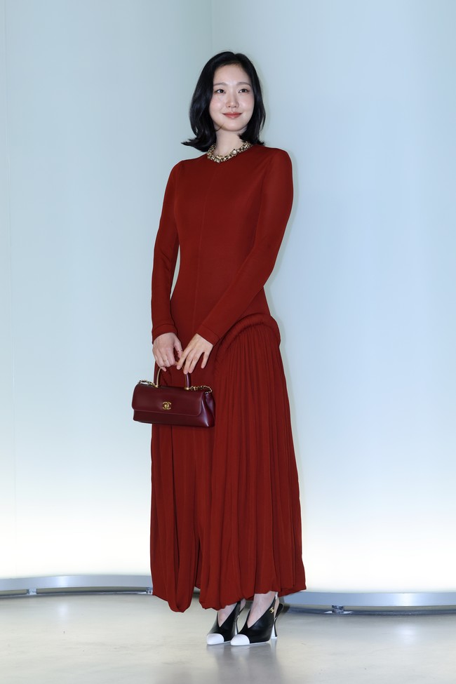 Kim Go Eun kembali ke show Chanel sebagai perwakilan rumah mode Prancis tersebut. Tampil memancarkan keanggunan memakai gaun panjang berwarna red wine, beraksen detail lipit yang terlihat bergelombang saat berjalan. Bintang Yumi’s Cells 3 itu memadukannya dengan hand bag senada. Foto: Getty Images
