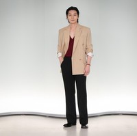 Park Seo Joon tampil beda dengan atasan merah berkerah V dibalut blazer berwarna krem. Sang aktor memancarkan karismanya dengan sleek back hair, yang mengekspos bagian dahinya. Foto: Getty Images
