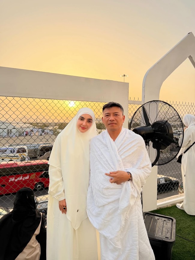 Pasangan Ashanty dan Anang Hermansyah menjadi salah satu artis yang paling banyak disorot saat menjalani ibadah haji 2026. Ashanty tampil anggun memakai gamis putih longgar dipadukan khimar lebar bernuansa ivory. Sementara Anang mengenakan kain ihram putih bersih dengan tampilan sederhana. (Foto: Instagram/@ashanty_ash)