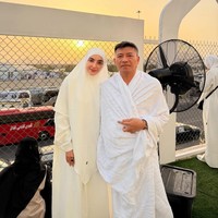 Pasangan Ashanty dan Anang Hermansyah menjadi salah satu artis yang paling banyak disorot saat menjalani ibadah haji 2026. Ashanty tampil anggun memakai gamis putih longgar dipadukan khimar lebar bernuansa ivory. Sementara Anang mengenakan kain ihram putih bersih dengan tampilan sederhana. (Foto: Instagram/@ashanty_ash)