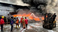 Petugas damkar berjibaku menyemprotkan air ke dalam pabrik yang terbakar. Amukan si jago merah begitu cepat menjalar ke hampir semua area dalam fasilitas pengolahan ban bekas ini.