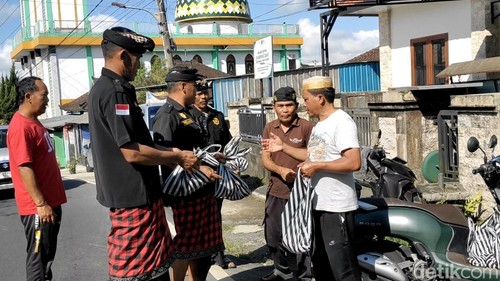 Warga Angantiga membagikan daging kambing kurban kepada warga Hindu, tetua adat hingga pecalang di kampung tersebut, Rabu (27/5/2026).