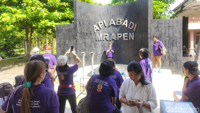 Peserta pengambilan Api Dharma Waisak di situs Api Abadi Mrapen berfoto di titik api.