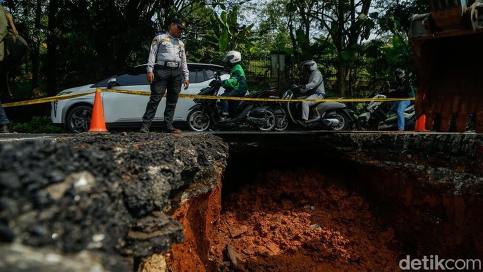 Jalan Raya Lenteng Agung, Jakarta Selatan, mengalami amblas hingga memicu penyempitan arus lalu lintas, Jumat (29/5/2026).