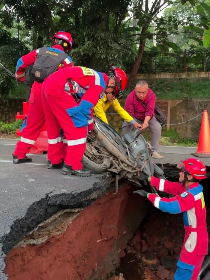 Jalan Raya Lenteng Agung di Jakarta Selatan (Jaksel) amblas hingga menimbulkan lubang cukup besar. Seorang pemotor terperosok lubang di jalan tersebut. (dok Damkar)