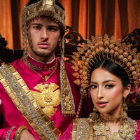 Jennifer Coppen dan Justin Hubner tampil kompak mengenakan baju Bodo bernuansa pink fuchsia yang mencolok. Busananya dipenuhi detail payet dan bordir emas yang sangat ramai, memberi kesan royal bak pengantin kerajaan tradisional. Foto: Instagram/@jennifercoppenreal20