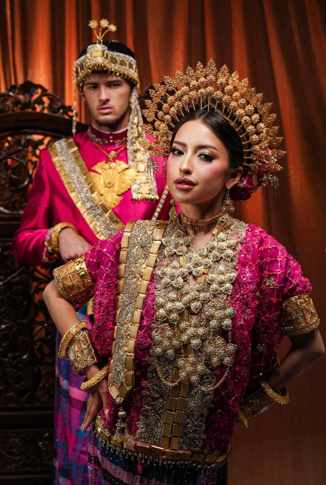 Penampilan Jennifer makin lengkap dengan mahkota adat berbentuk melingkar dengan ornamen bunga emas menjulang di sekeliling kepala. Sementara Hubner mengenakan aksesori kepala yang juga berwarna keemasan, membuat penampilannya semakin gagah. Foto: Instagram/@jennifercoppenreal20