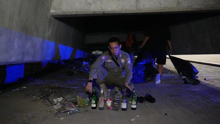 Petugas membersihkan sampah di kolong Tol Layan AP Pettarani, Makassar.