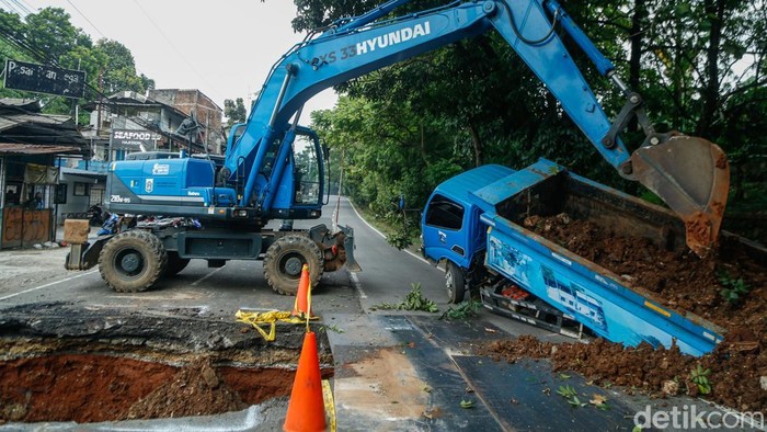 Sebuah truk Sudin SDA Jakarta terperosok di samping lubang besar di Jalan Lenteng Agung, Jakarta, Jumat (29/5/2026).