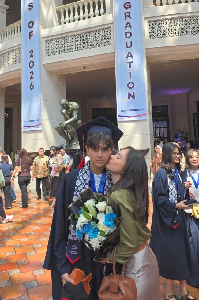 Wulan tampil feminin dengan setelan casual saat menghadiri acara wisuda SMP putranya, Jeremiah Alric Dimitri. Sang putra diketahui baru saja menyelesaikan pendidikan tingkat SMP dari Sampoerna Academy. Foto: Instagram/@wulanguritno