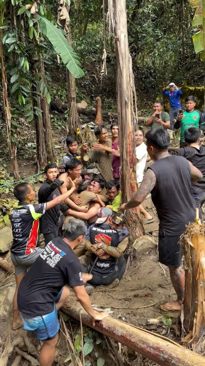 Detik-detik Menegangkan Penyelamatan Penambang Emas di Gua Sempit A rescued man is supported by a volunteer, after seven Lao nationals who had entered a cave to prospect for gold were trapped for more than a week when rising water blocked their exit, in Xaisomboun province, Laos, May 30, 2026, in this screen grab taken from social media video.